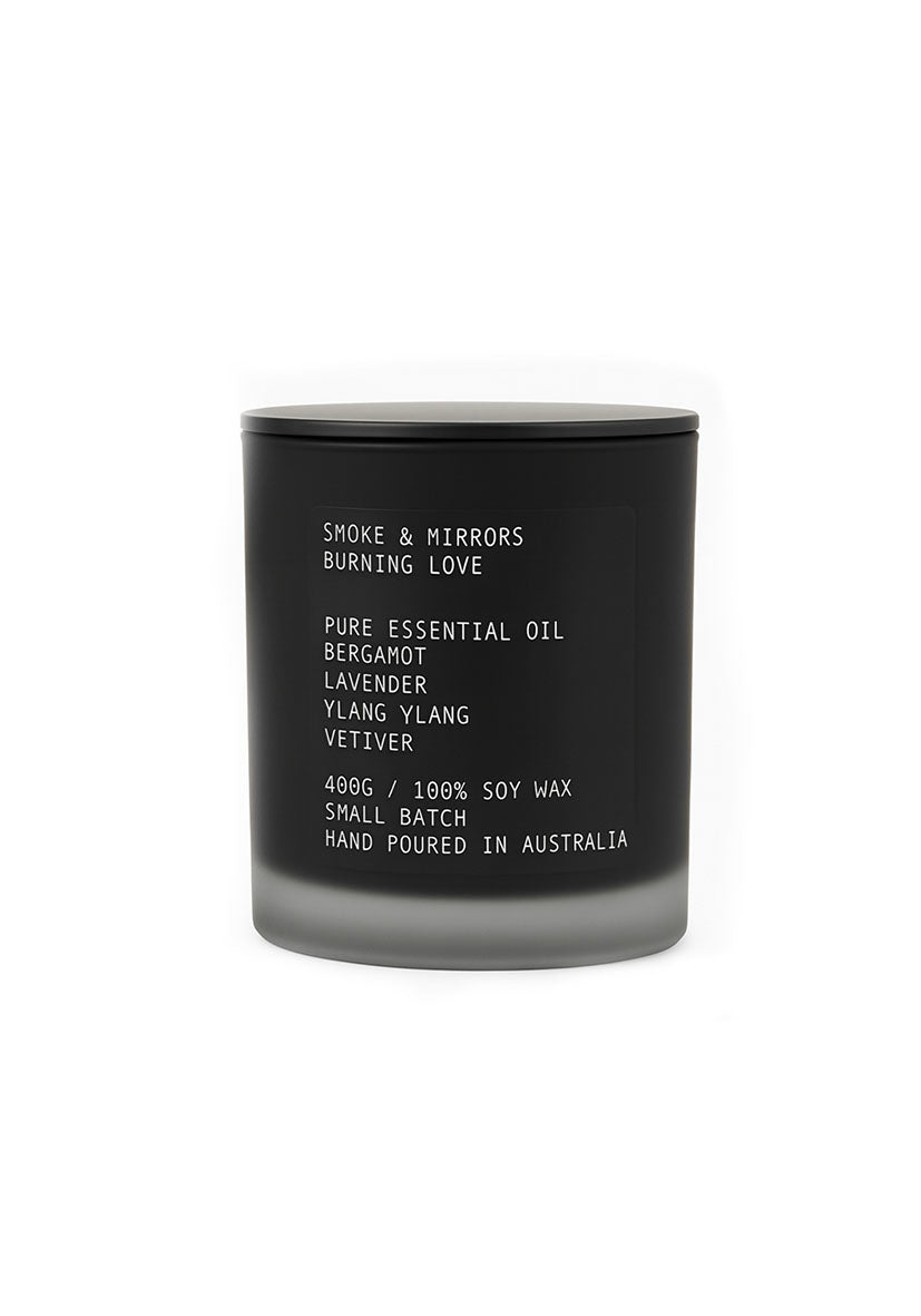 Black candle with white text on a white background