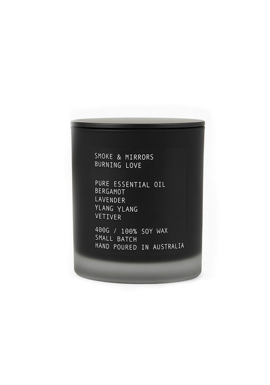 Black candle with white text on a white background